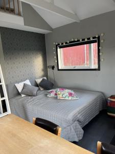 a small bedroom with a bed and a window at Stuga nära havet in Ystad