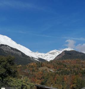 een besneeuwde bergketen met een huis op de voorgrond bij Loft lumineux et confortable in Grimisuat