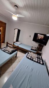 a room with two beds and a flat screen tv at Hostel My House quartos perto do aeroporto de Guarulhos in Guarulhos