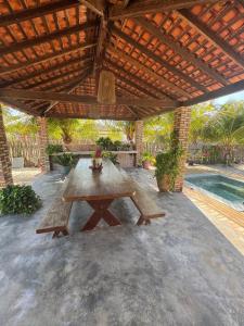 a wooden picnic table under a wooden roof on a patio at Vivi Beach Macapá in Luis Correia