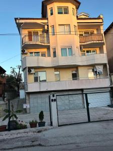 un grand bâtiment avec une clôture devant lui dans l'établissement White House Apartments - Studio Lux, à Haskovo