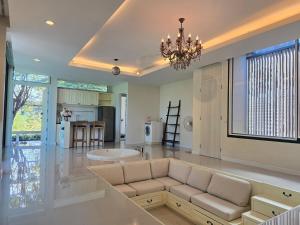 ein Wohnzimmer mit Couch und Küche in der Unterkunft Relax home surrounded by nature near town 15 min in Chiang Mai