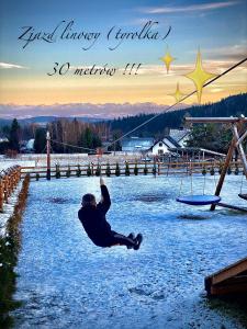 a man is sitting in the middle of a river at ORAWSKA CHATA - domek z balią pod Babią Górą in Zubrzyca Górna