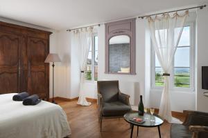 a bedroom with a bed and a chair and a table at Maison d'hôtes La Chevalée in Hautvillers +21 photos
