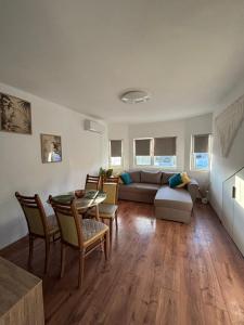 a living room with a couch and a table and chairs at White House Apartments - Forest in Haskovo