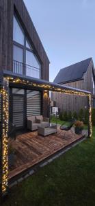 Una terraza de madera con luces en la parte superior de una casa. en Kuršių Vėjai, en Palanga