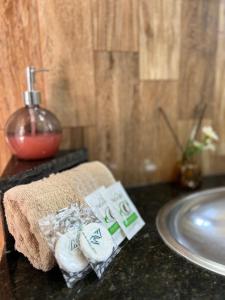 eine Badezimmertheke mit einem Handtuch und einem Waschbecken in der Unterkunft Estalagem pé na areia in Arraial do Cabo