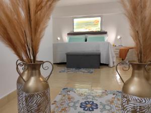 a room with two vases on the floor with a bed at Opera Prima 28 in Palermo