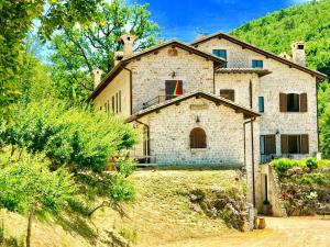 ein altes Steinhaus auf einem Hügel in der Unterkunft Villa Sole Vini in the Heavenly Heart of Umbria on Top of the World sleeps 50 in Bazzano di Spoleto