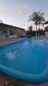 ein großer blauer Pool mit einem Springbrunnen in der Unterkunft Casa de praia com área de lazer in Nísia Floresta