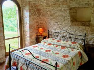 ein Schlafzimmer mit einem Bett in einer Steinmauer in der Unterkunft Villa Sole Vini in the Heavenly Heart of Umbria on Top of the World sleeps 50 in Bazzano di Spoleto + 179 Fotos