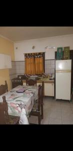 a kitchen with a table and a kitchen with a refrigerator at Casa cómoda familiar in La Plata