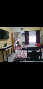 a living room with a table and a desk at Casa cómoda familiar in La Plata