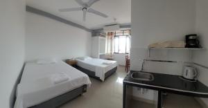 a room with two beds and a desk and a window at Hospedaje Luciana in Pucallpa