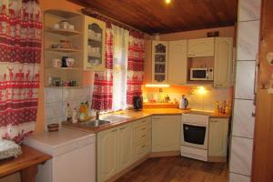 a small kitchen with white cabinets and a sink at Chalupa u Jizery in Rokytnice nad Jizerou +9 photos