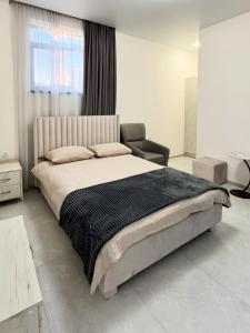 a bedroom with a large bed and a chair at Ultra Energy Hotel in Yeghegnadzor