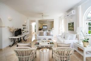 een woonkamer met een witte bank en stoelen bij Sugar Hill - Jade Vine 3 bed villa in Saint James