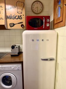 a microwave sitting on top of a refrigerator in a kitchen at Anayet Sweet Home in Formigal +35 photos