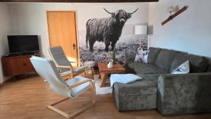a living room with a couch and a cow on the wall at Chalet Ecureuil à Champoussin - Portes du Soleil in Champoussin