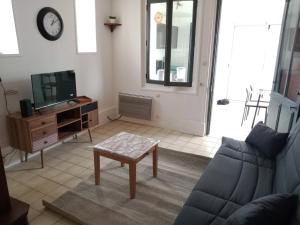 a living room with a couch and a tv at Les Galets in Fécamp