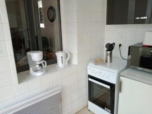 a kitchen with a stove and a microwave at Les Galets in Fécamp