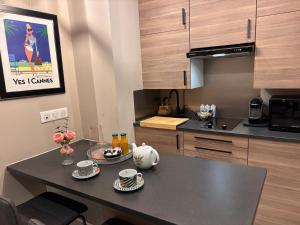 a kitchen with a table with cups and plates on it at Boulevard de la croisette PALAIS MIRAMAR in Cannes