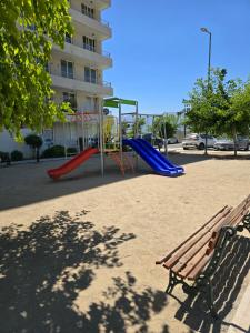 a park with a playground with a slide and a bench at Rancagua Lujo y comodidad Depto con Piscina y Estacionamiento in Rancagua