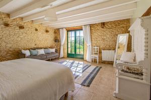 a bedroom with a bed and a couch and a window at La Mouy - Périgord Noir - Farmhouse with pool in Mauzens-et-Miremont