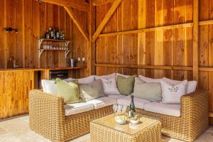 a living room with a couch and wicker chairs at La Mouy - Périgord Noir - Farmhouse with pool in Mauzens-et-Miremont