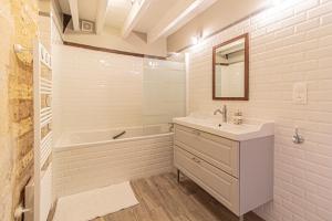 a white bathroom with a sink and a tub and a sink at La Mouy - Périgord Noir - Farmhouse with pool in Mauzens-et-Miremont