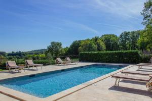 a swimming pool with chaise lounges and chairs around it at La Mouy - Périgord Noir - Farmhouse with pool in Mauzens-et-Miremont +15 photos