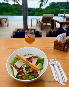 - un bol de salade et un verre de vin sur une table dans l'établissement Villa Francia, à San Juan del Sur