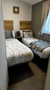 two beds in a small room with at Big Boss Caravan-Camber Sands,Sleep 8, Free Wi-Fi, Netflix, Parking in Camber +26 photos
