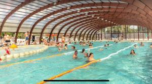 eine Menschenmenge schwimmt in einem Schwimmbecken in der Unterkunft Tohapi camping Atlantic Club in Montalivet-les-Bains