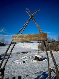 un panneau en bois dans la neige, avec un champ enneigé dans l'établissement FeWo Bergruh 922 im Ferienpark Oberallgäu, à Missen-Wilhams