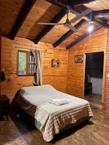 a bedroom with a bed in a wooden room at Casa de campo el lapacho in Colonia Mbopicuá