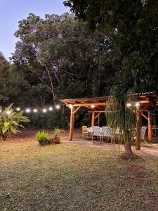a patio with a table and chairs under a pergola at Casa de campo el lapacho in Colonia Mbopicuá +18 photos