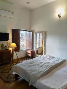 Un dormitorio con una cama grande y un espejo. en Khurja Wali Dharamshala, en Rishīkesh