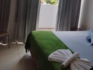 a bedroom with a bed with a towel on it at Hotel Vitória - Guaíra in Guaíra