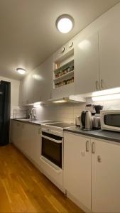 a kitchen with white cabinets and a stove top oven at Wesfield Private in Solna
