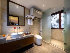 Un baño con lavabo y ducha en Lijiang Ancient Town Landscape Garden Hotel 山水爱斯花园酒店, en Lijiang