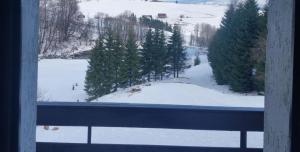 a window with a view of a snow covered mountain at Gościniec, kwatery prywatne przy stoku w Zieleńcu in Duszniki Zdrój