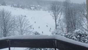a group of people skiing down a snow covered slope at Gościniec, kwatery prywatne przy stoku w Zieleńcu in Duszniki Zdrój