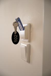 une clé accrochée à une porte avec un porte-clés dans l'établissement Anesis Airport rooms 102, à Koropíon