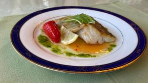 une assiette de nourriture avec de la viande sur une table dans l'établissement ペンションあけまの森, à Daisen