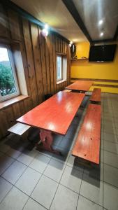 a group of wooden tables in a room at Jaunrūtiņas dīķis in Salaspils +1 photo