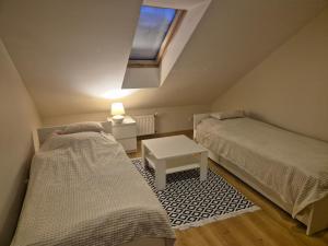 deux lits dans une petite pièce avec une fenêtre dans l'établissement Orzechowa Zagroda, à Nowa Słupia