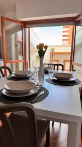 a table with plates and glasses and a vase with flowers at Gioia's House in Montesilvano +33 photos