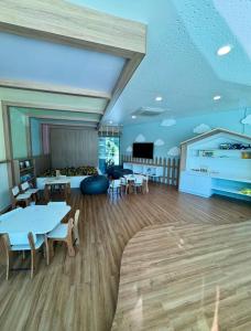 een grote kamer met tafels en stoelen en een tv bij Flat Beach Class Verano- Praia de Muro Alto- Porto de Galinhas in Ipojuca