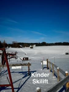 un champ recouvert de neige avec une clôture et un champ recouvert de neige dans l'établissement FeWo Bergruh 922 im Ferienpark Oberallgäu, à Missen-Wilhams